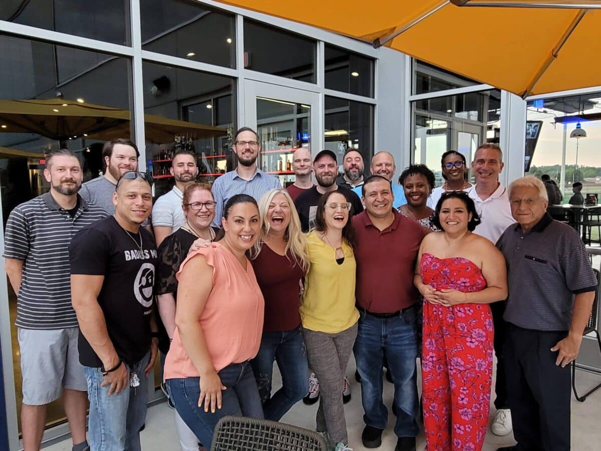 A group of people posing for a photo in front of a restaurant.