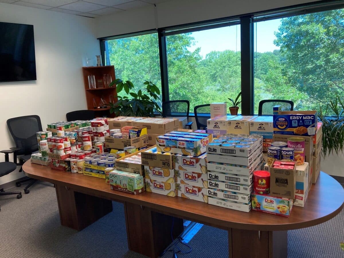 A large table filled with boxes of food in an office.