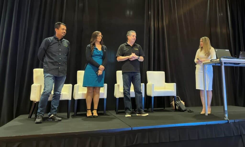 A group of people standing on stage at a conference.