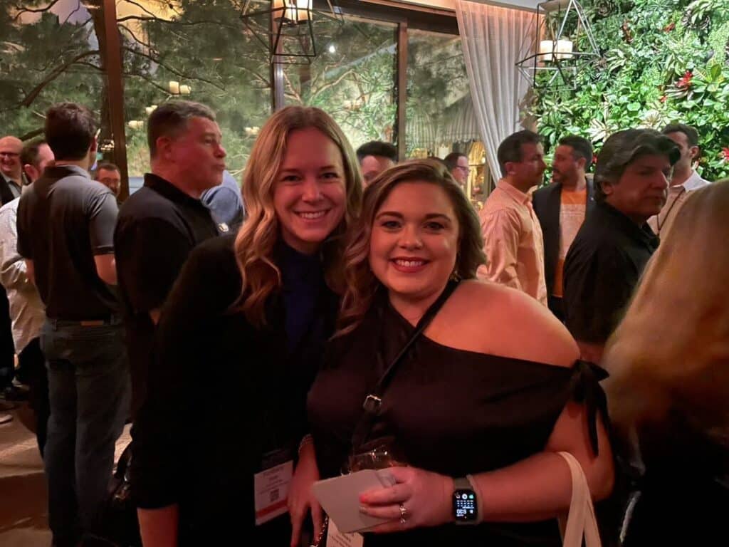 Two women posing for a photo at an event.