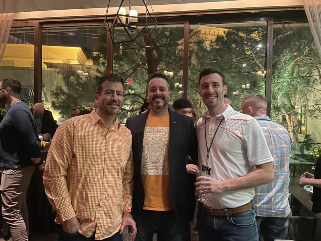Three men standing next to each other at an event.