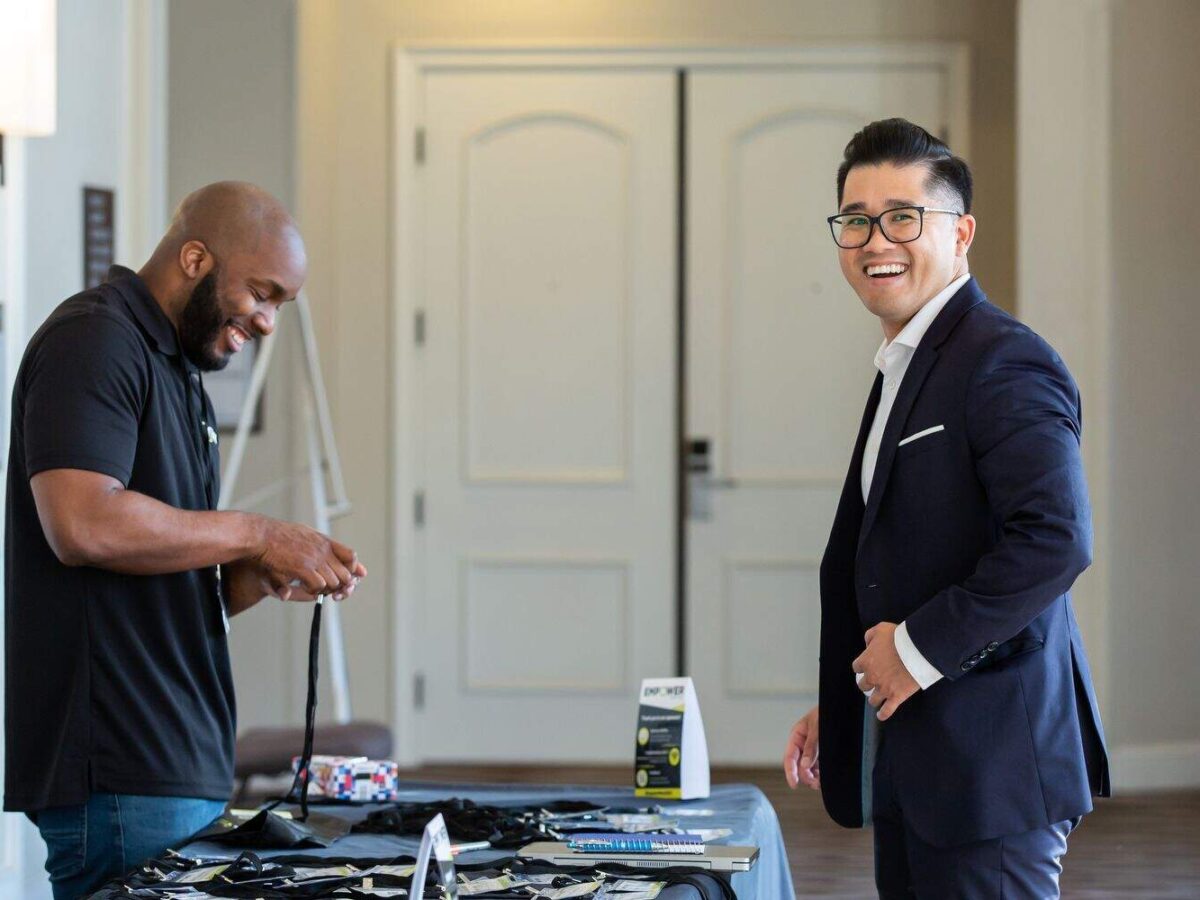 A man in a suit and tie is smiling at a table.