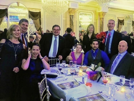 A group of people posing for a picture at a formal dinner.
