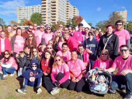 A group of people in pink shirts posing for a photo.