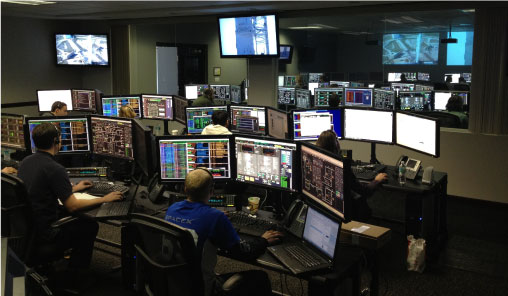 A group of people working on computers in a control room.