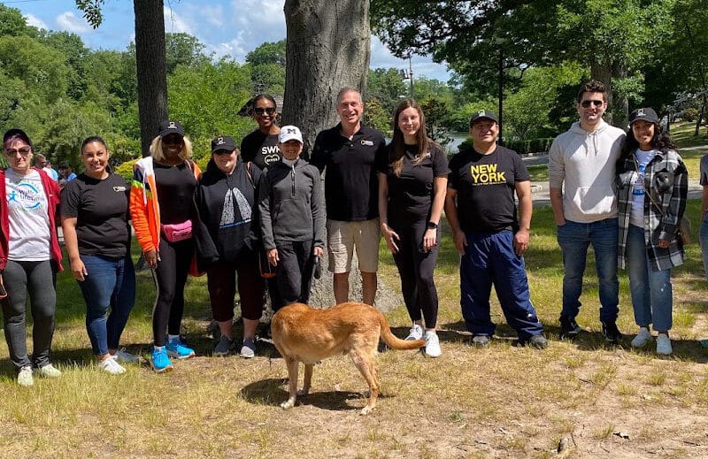 A group of people posing for a photo with a dog.