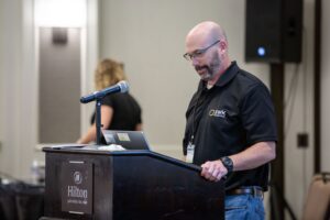 A man standing at a podium with a laptop.