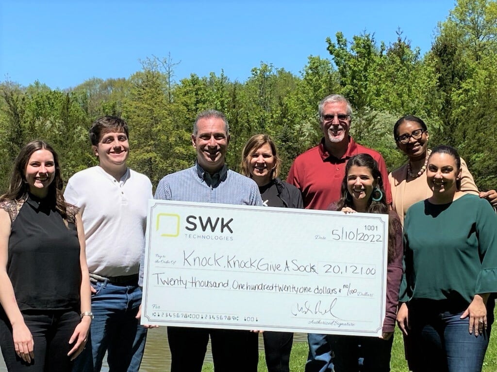 A group of people posing for a picture with a large check.