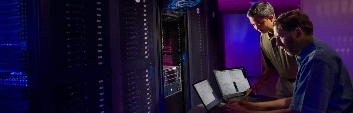 Two men working in a server room.