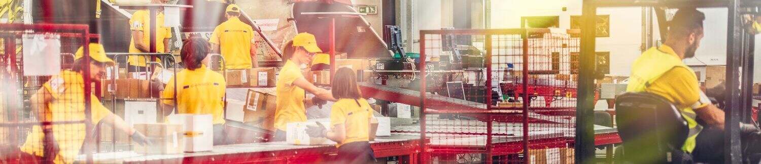 A blurry image of people working in a warehouse.