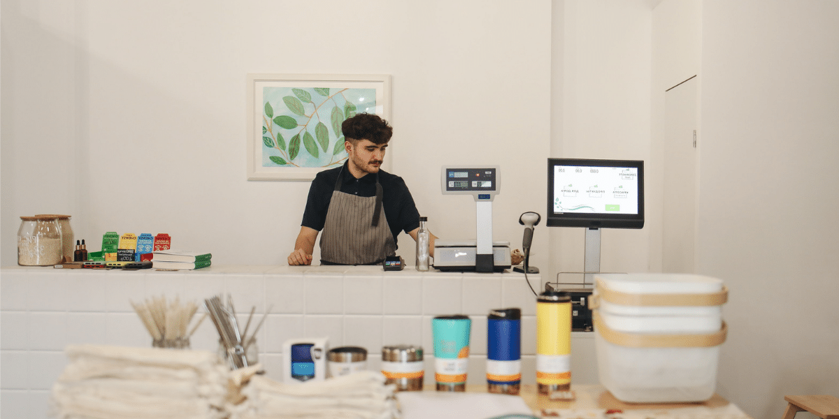 A woman is standing at the counter of a store.