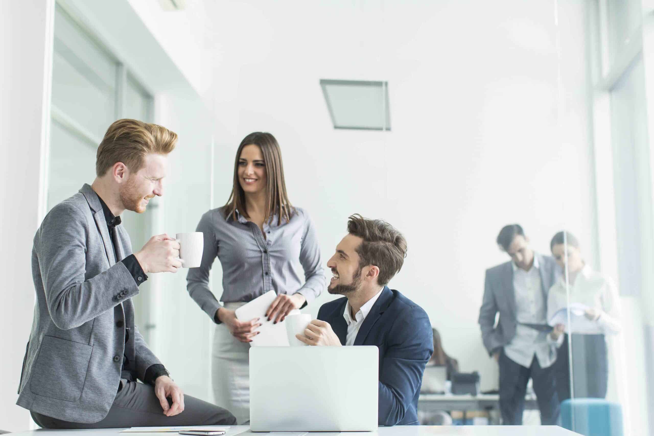 A group of business people sitting around a table in an office.