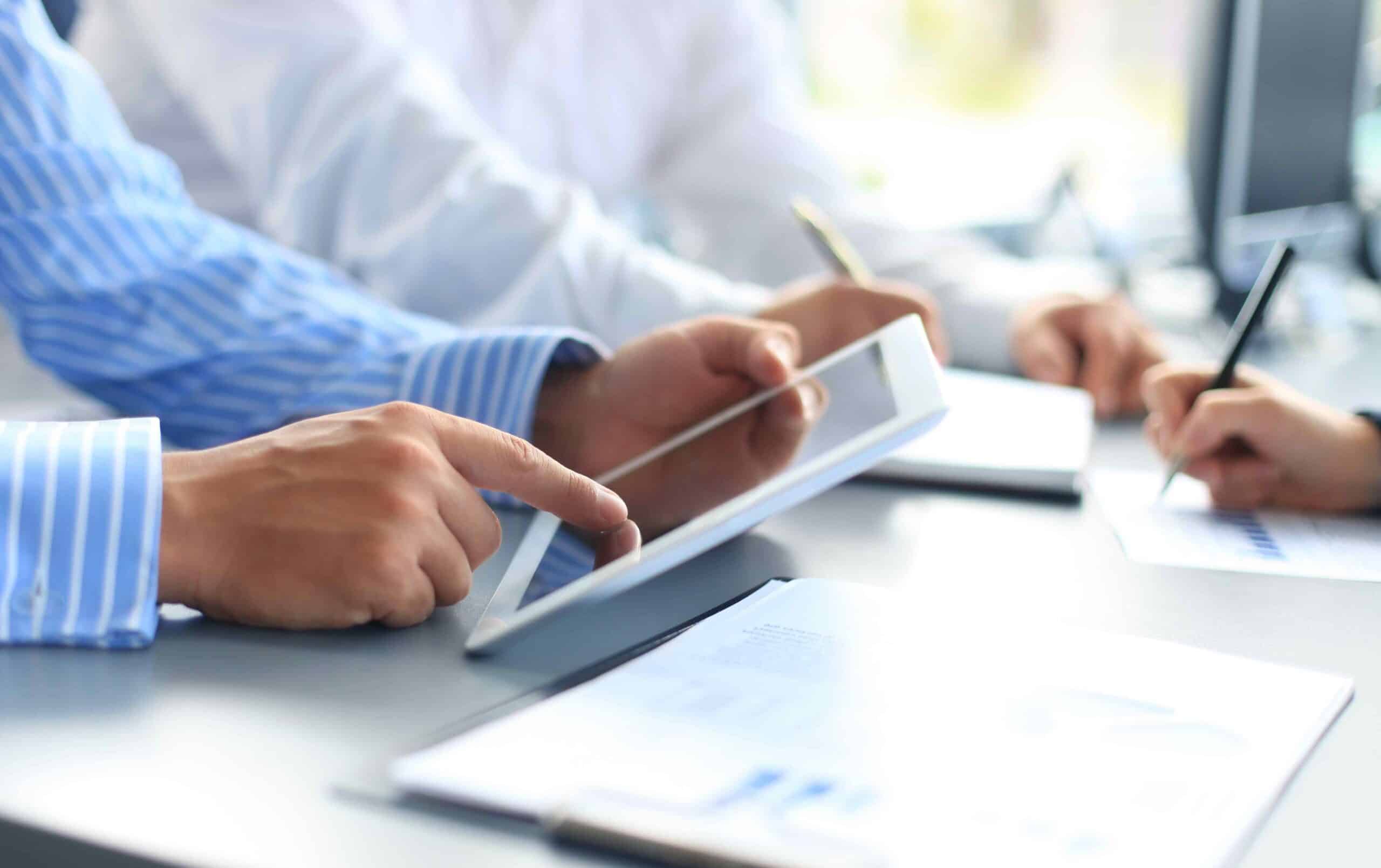 A group of business people working on a tablet.