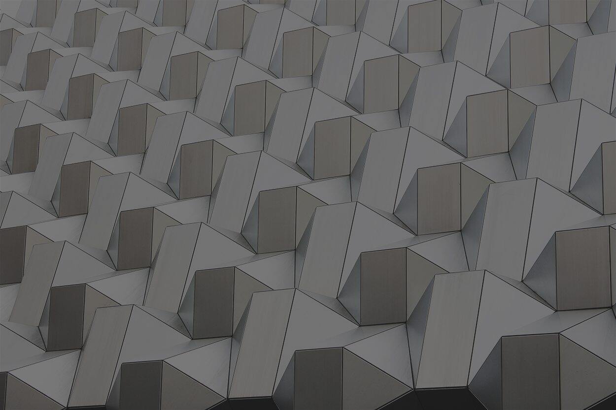 A close up of a gray wall with many geometric shapes.