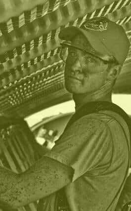 A man wearing a helmet and glasses is working on a roof.