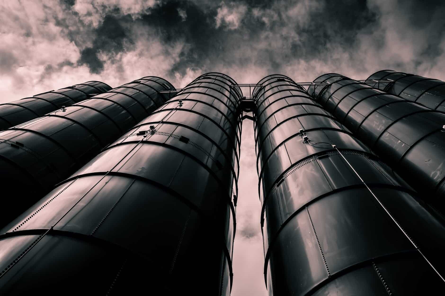 A black and white photo of a group of metal barrels.