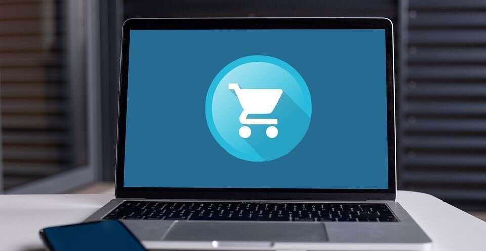 A laptop with a shopping cart icon on it.
