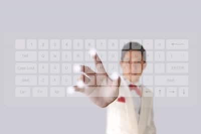 A man in a suit is touching a keyboard.
