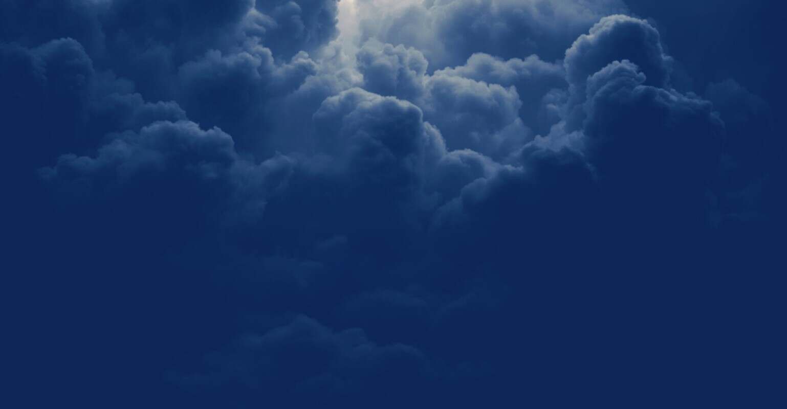 A dark night sky with clouds and a moon.