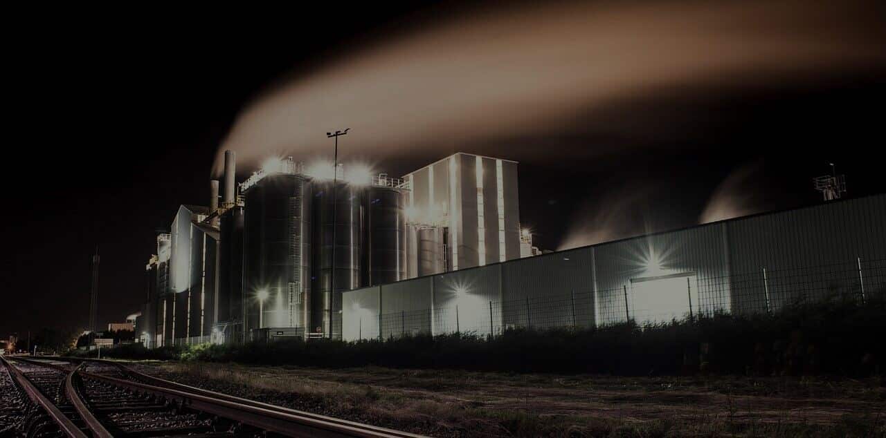 A factory with smoke coming out of it at night.