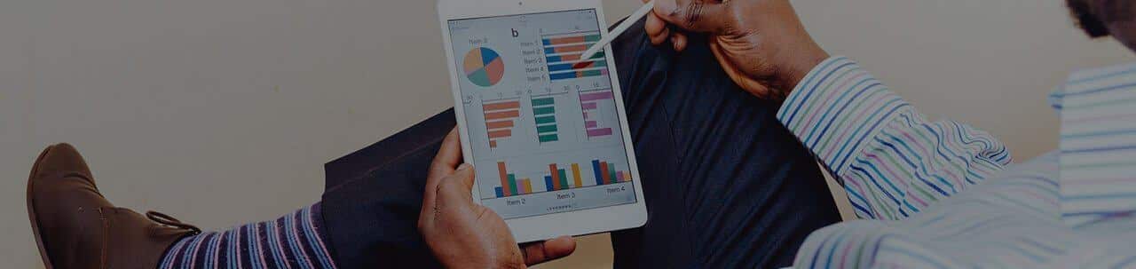 A man holding a tablet with graphs on it.