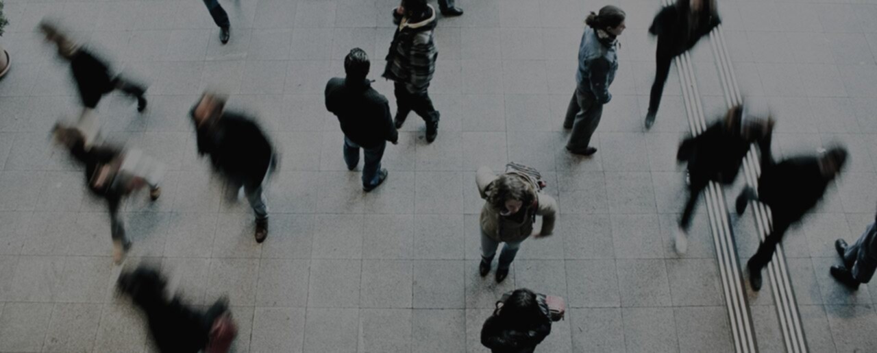 A group of people walking on a tiled floor.