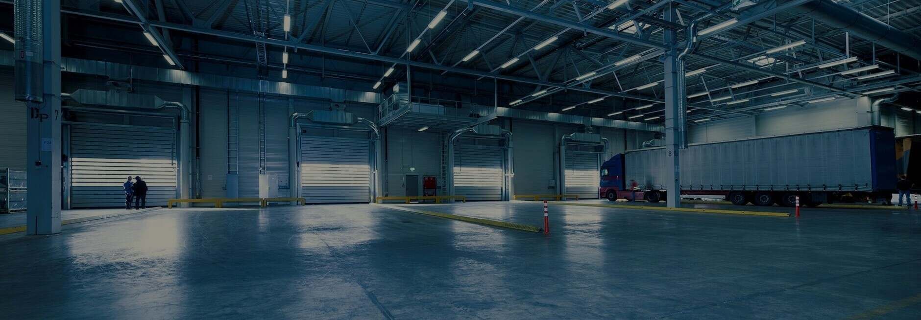 A large warehouse with a truck parked in it.