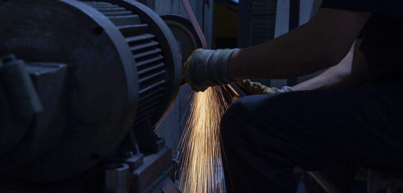 A man is working on a machine with sparks.
