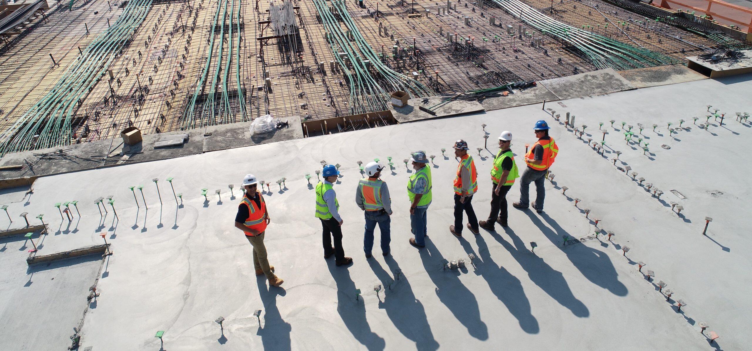 A group of construction workers standing on a construction site.