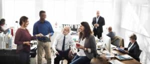 A group of people sitting around a table in an office.