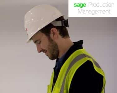 A man in a hard hat looking at a tablet.