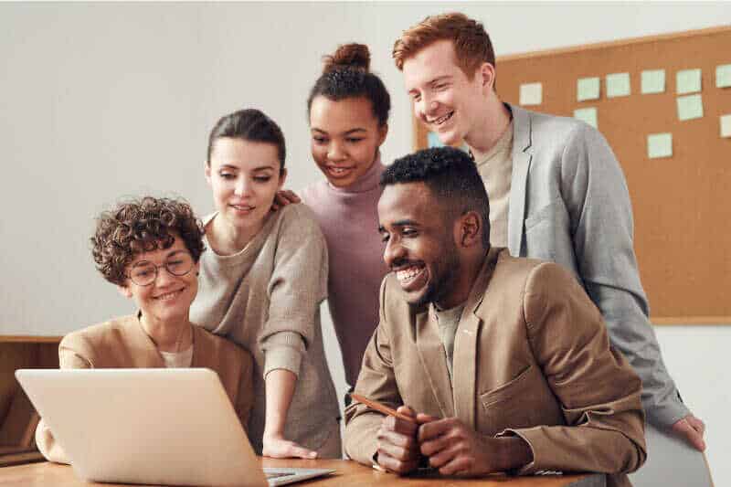 A group of people looking at a laptop.