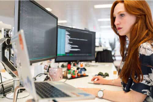 A woman working on a computer in an office.