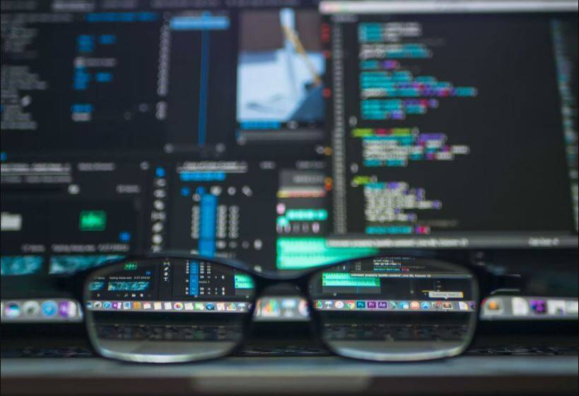 A pair of glasses in front of a computer screen.