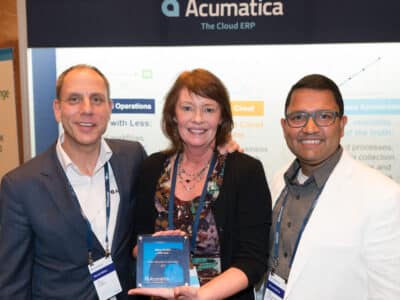 Three people posing for a photo with an award.