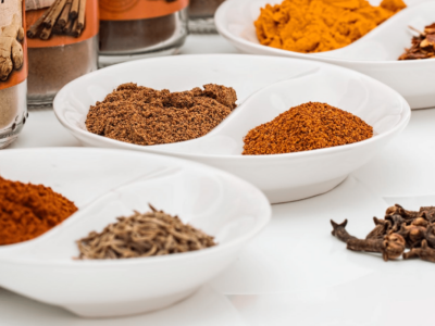 A variety of spices in bowls on a white surface.