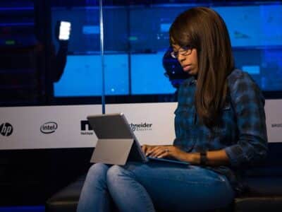 A woman sitting on a couch with a laptop.