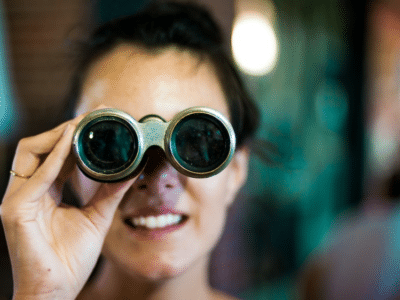 A woman looking through a pair of binoculars.