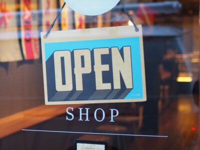 An open shop sign in the window of a shop.