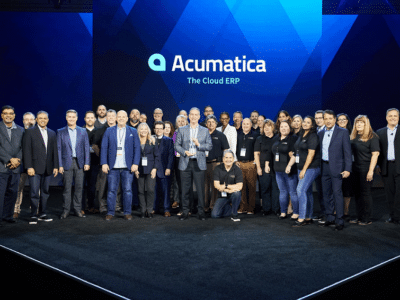 A group of people standing on a stage with the word Acumatica.