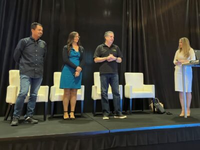 A group of people standing on stage at a conference.