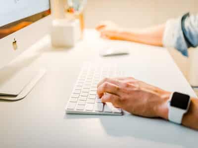 A person typing on a computer keyboard.