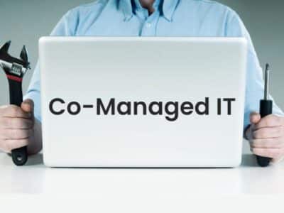 A man holding a laptop with the words Co-Managed IT.