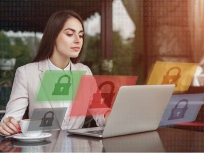 A woman is sitting at a table with a laptop in front of her.