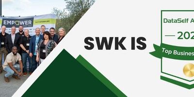 A group of people standing in front of a banner that says SWK is 2021.