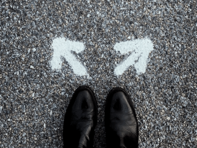 A pair of black shoes standing next to two arrows.