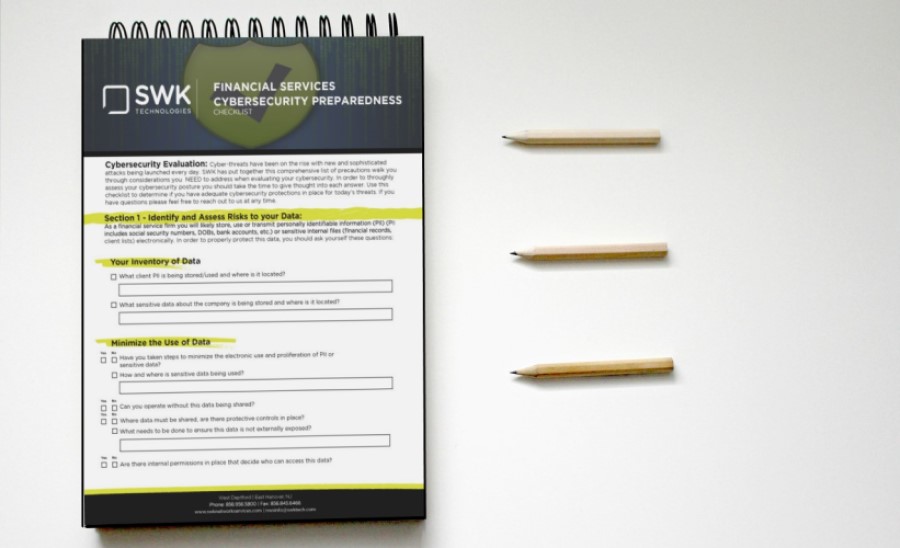 The SWK cybersecurity checklist for financial services displayed on the left with three pencils stacked horizontally on the right