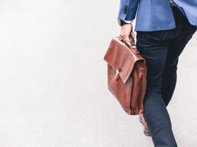 A man in a suit walking with a briefcase.