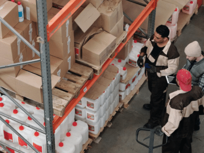 A group of people in a warehouse looking at boxes.