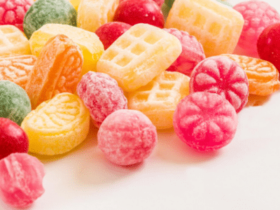 A pile of colorful candies on a white surface.